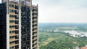 Un immeuble de grande hauteur doté de nombreux balcons et offrant une vue sur une rivière et la verdure environnante.