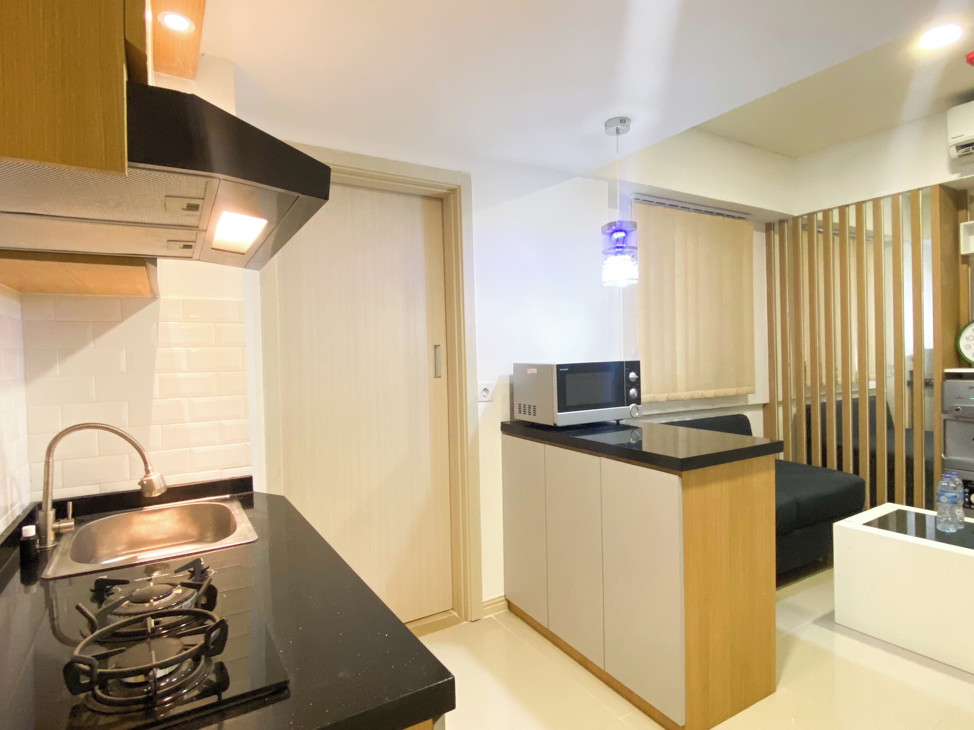 A compact kitchen with a gas stove, a microwave, and a sink.