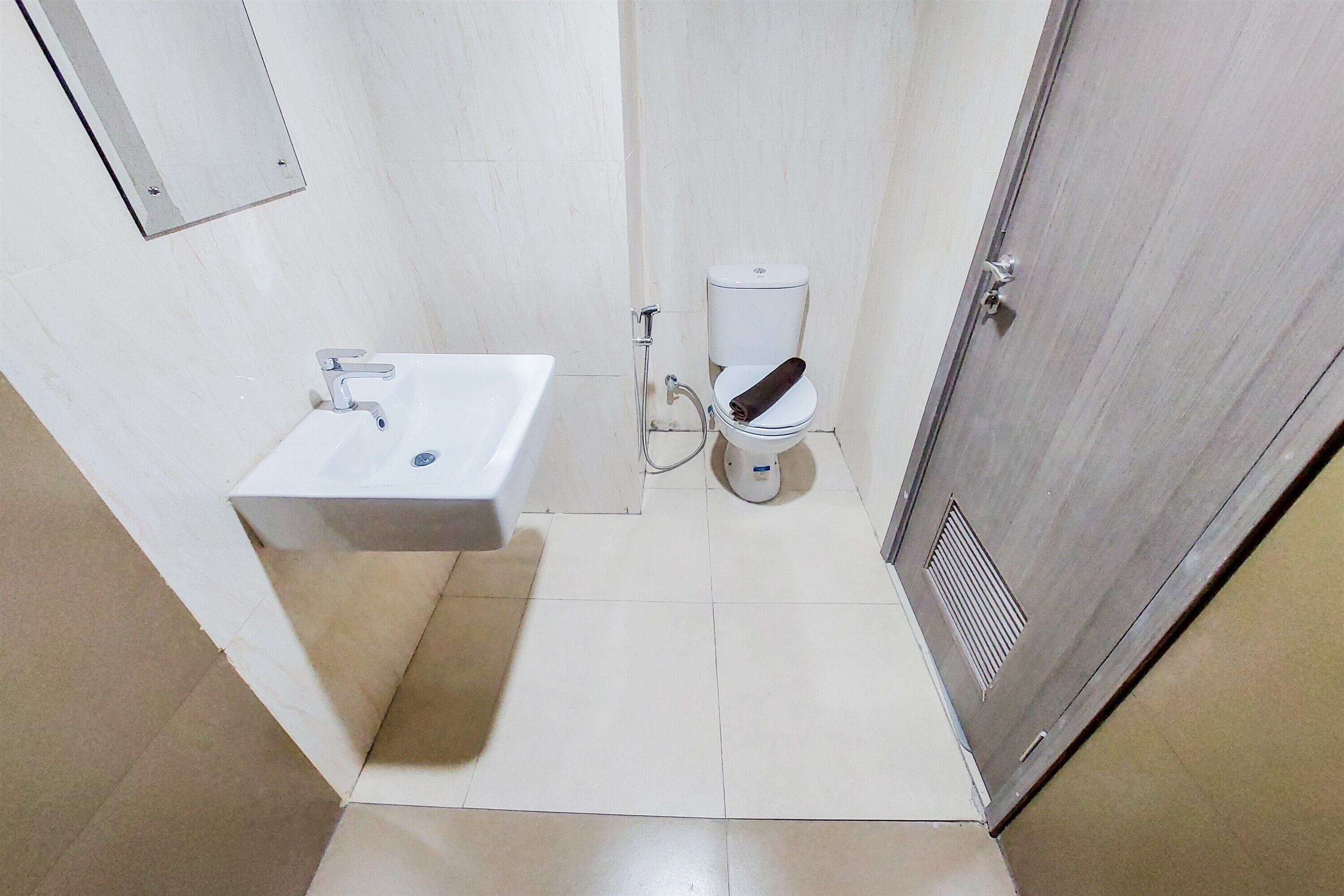 A small, clean bathroom with a white sink, toilet, and shower.