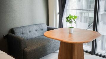 Una habitación moderna con un sofá gris, una mesa de madera y una planta en maceta.