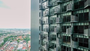 Un edificio de gran altura con múltiples balcones y vista a una zona residencial.