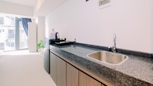 Una cocina moderna con encimera de granito, pileta de acero inoxidable y muebles de madera.