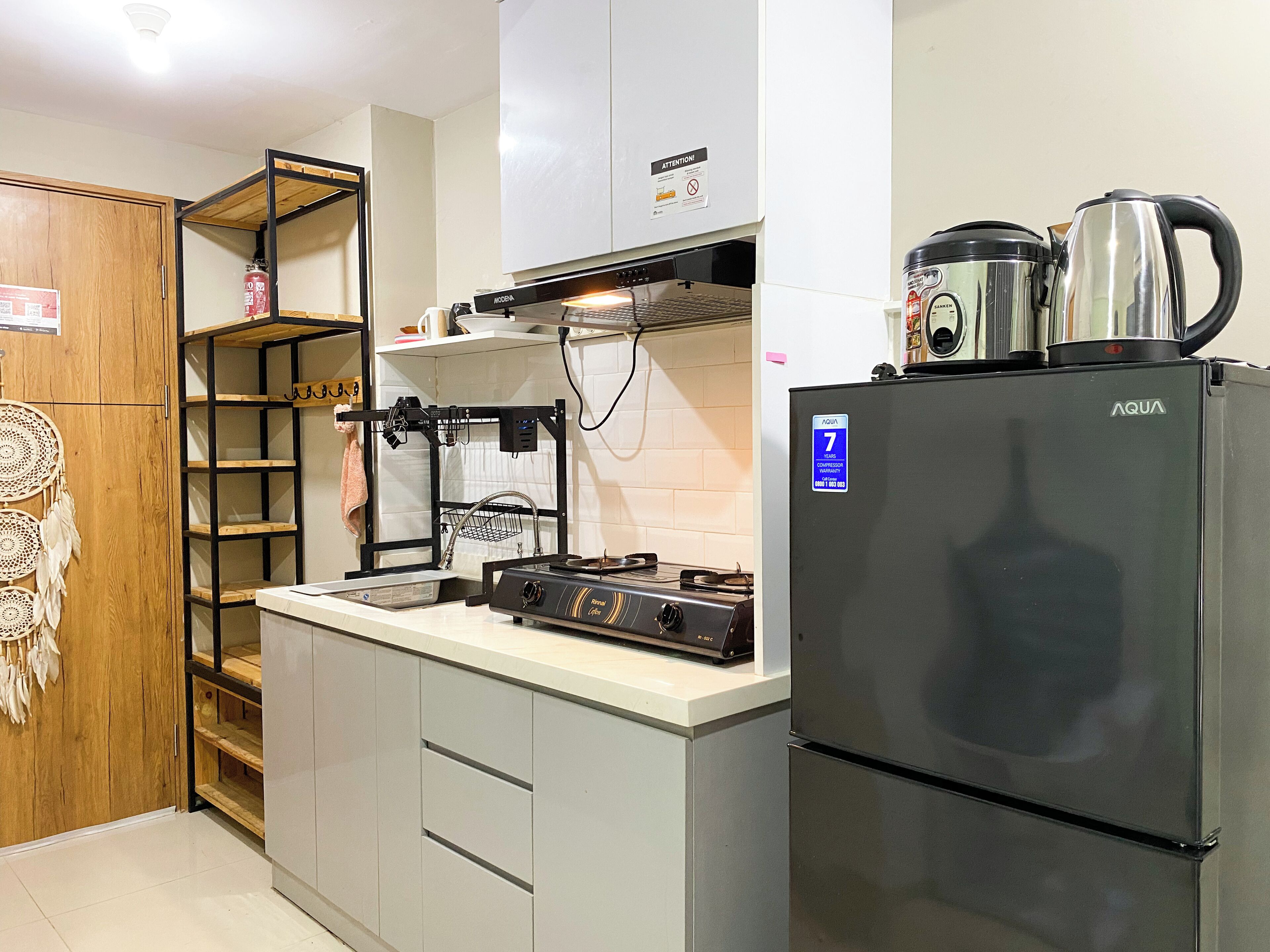 Une cuisine compacte équipée d’un réfrigérateur, d’une cuisinière et d’une machine à café.