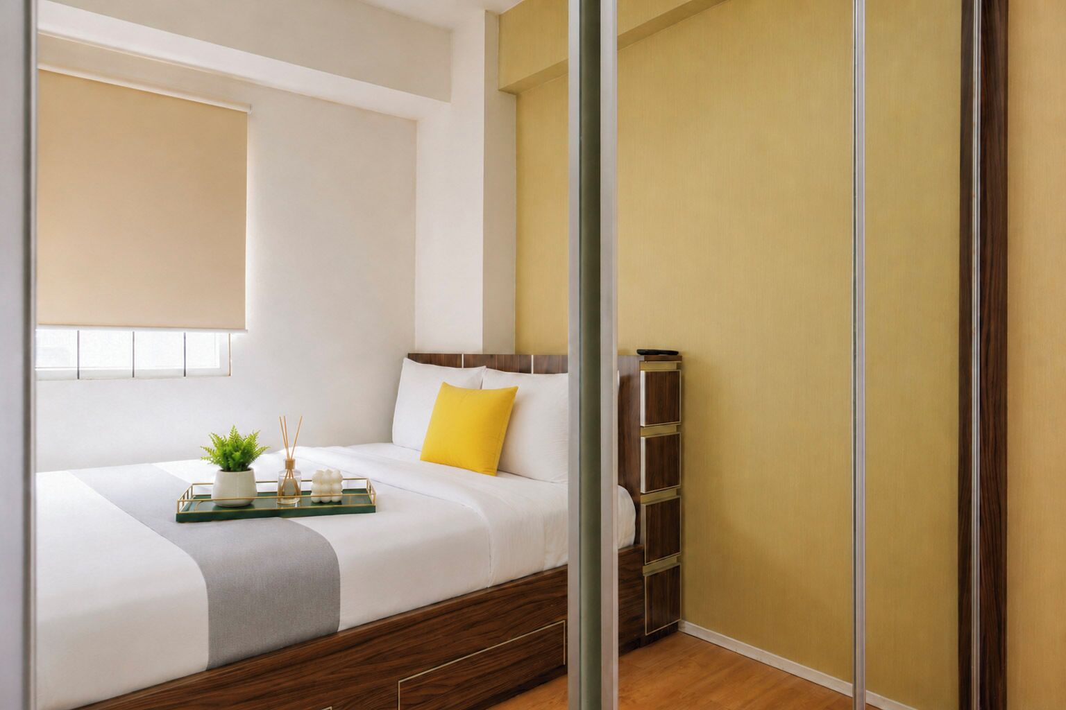 A modern bedroom with a bed, bedside table, and a window with blinds.