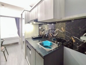 Studio | Private kitchen | Mini-fridge, stovetop - Homey Grey Studio Apartment at Grand Asia Afrika Bandung By Travelio (Bandung)