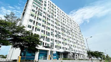 Un edificio de varios pisos con un diseño arquitectónico moderno, que presenta una serie de balcones y grandes ventanales.