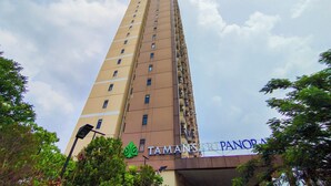 A tall, beige building with a sign reading "TAMANSARI PANORAMA". - Nice And Strategic Studio Room At Tamansari Panoramic (Bandung)