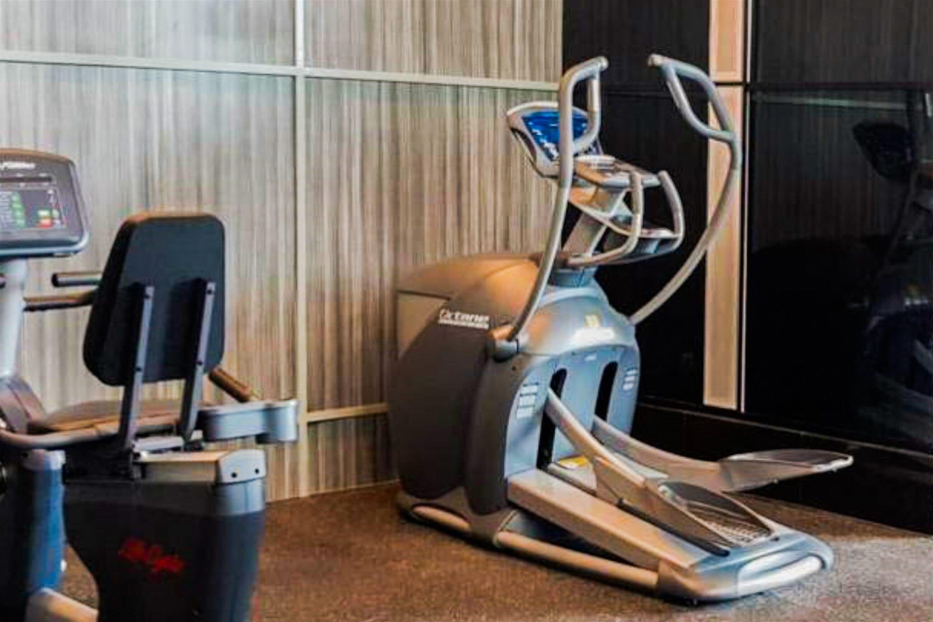 A gym with cardio machines, including a treadmill and an elliptical.