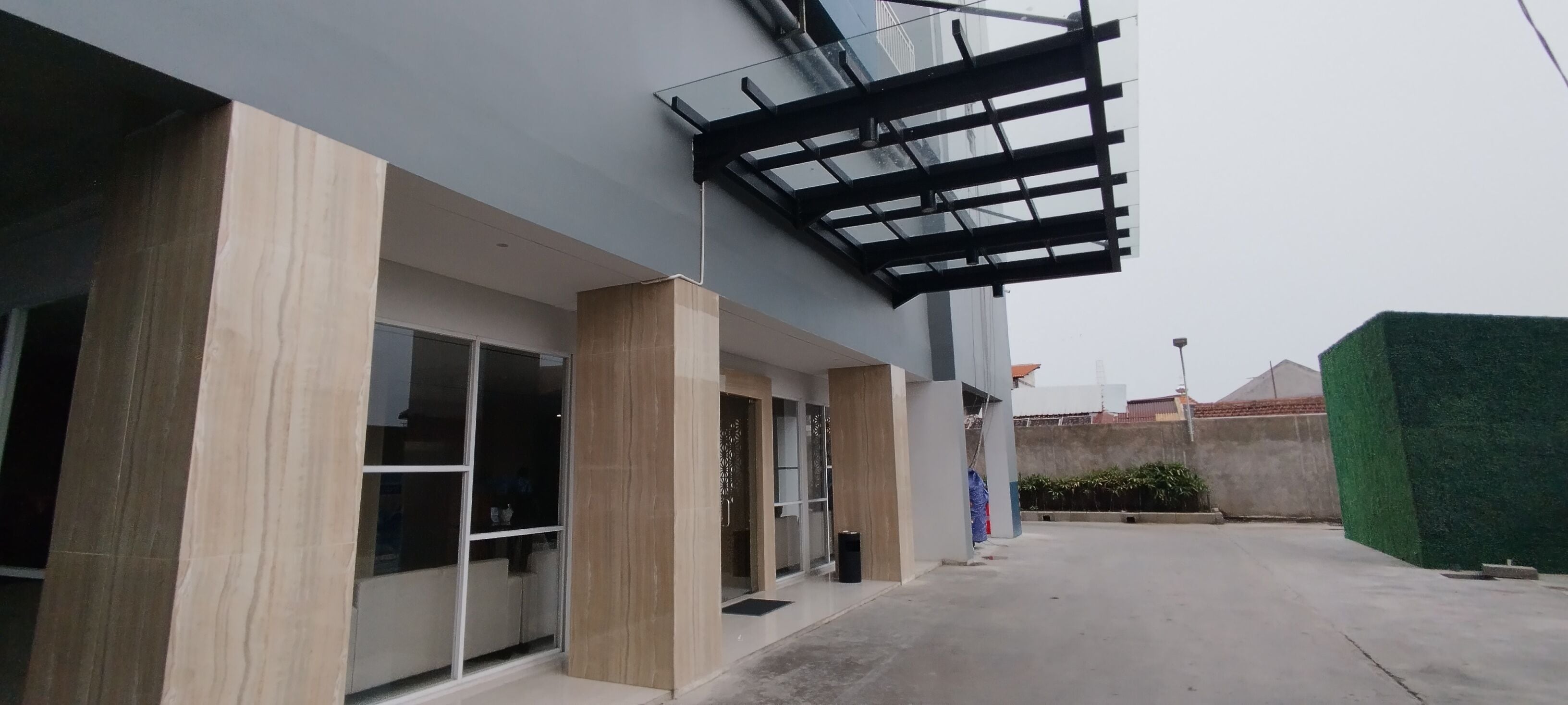 A modern building with large glass windows and a covered outdoor area.