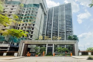 Um edifício residencial alto com varandas, entrada com portão e uma placa com a inscrição 'Sky House BSB'.