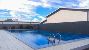 A swimming pool with clear blue water, surrounded by a tiled deck. - Good Deal And Comfortable Studio Park View Condominium Apartment (Depok)
