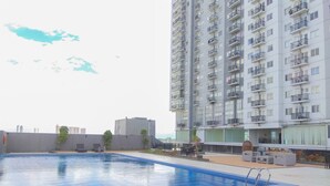 A rooftop swimming pool with a view of a high-rise building. - Best Deal And Comfortable Studio Park View Condominium Apartment (Depok)