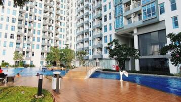 A residential building with multiple balconies, a swimming pool, and a covered outdoor area.