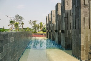 A pool area with a tiled floor and a stone wall. - Best Choice And Restful 1Br Citralake Suites Apartment (Jakarta)