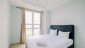 A hotel room with a large bed, a window with curtains, and a ceiling light. - Best Choice And Restful 1Br Citralake Suites Apartment (Jakarta)