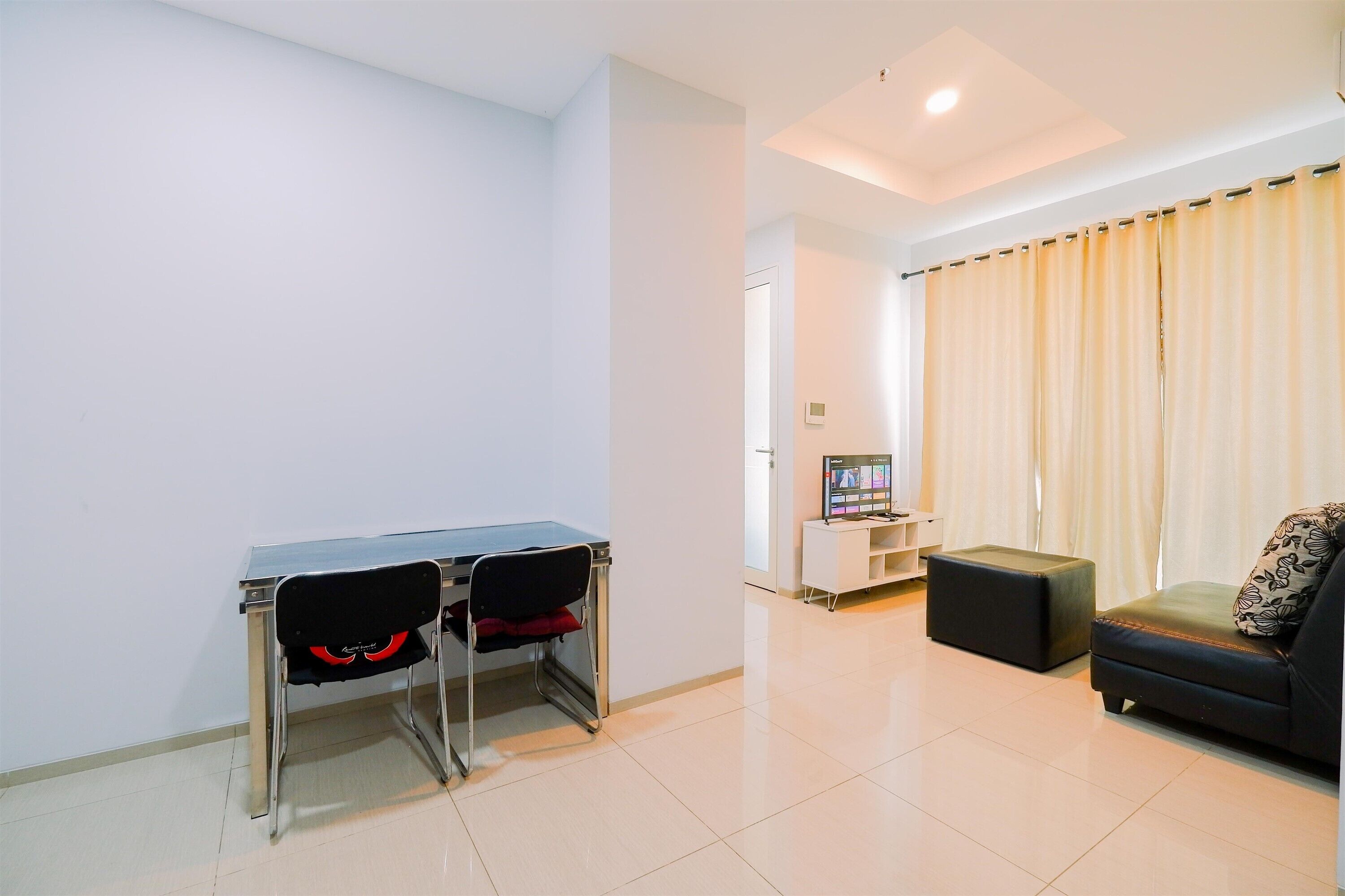 A living room with a desk, a sofa, and a television.