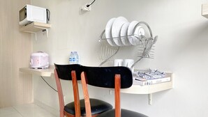 Un espacio de cocina compacto con microondas, un escurreplatos y una pequeña encimera.