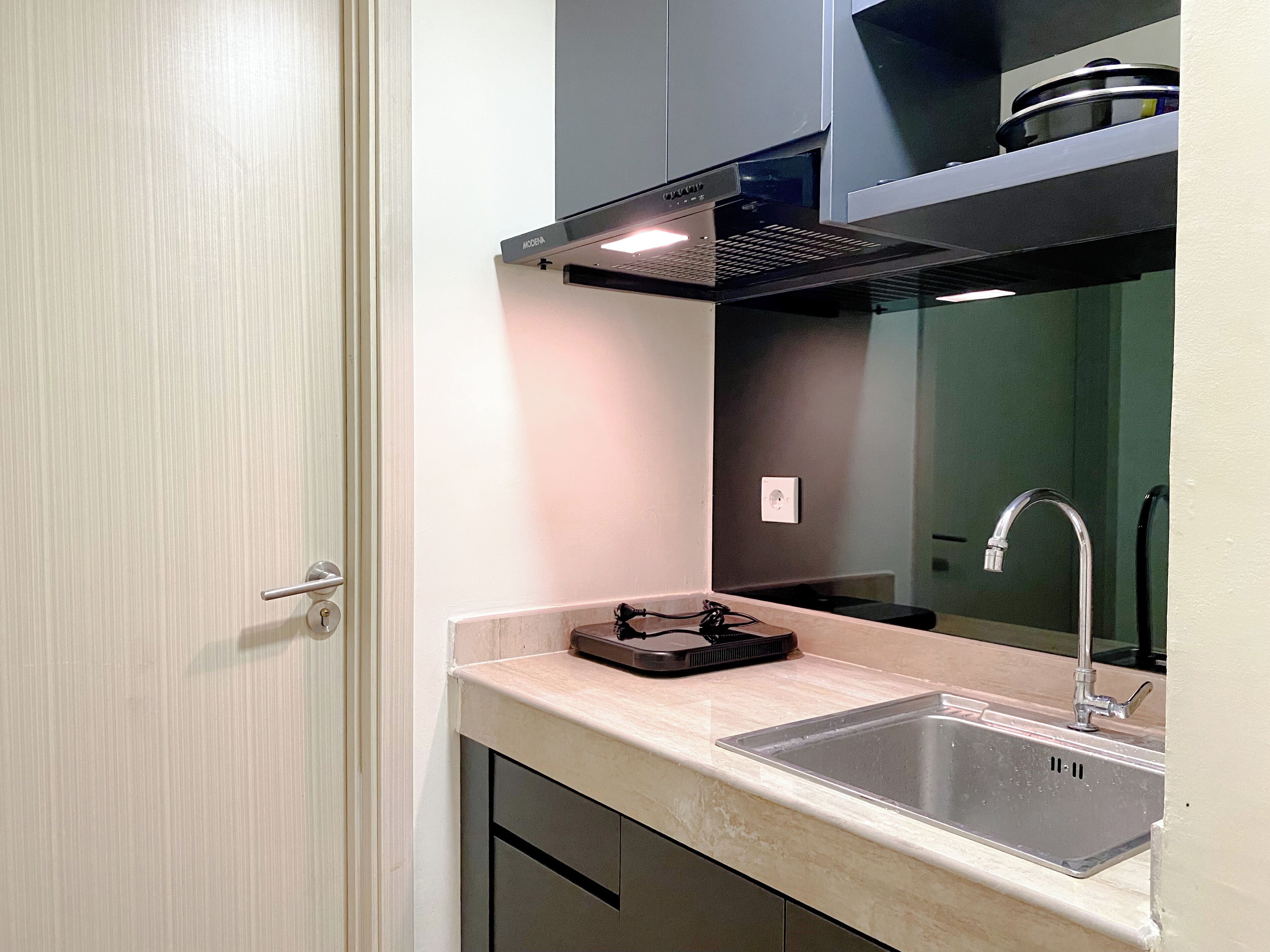 Una cocina compacta con un lavamanos, una estufa y un diseño moderno.