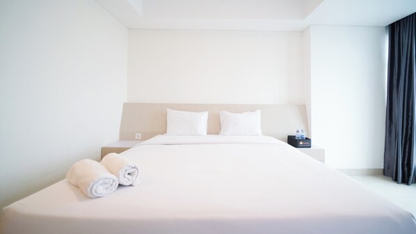 Relax in a serene space with a large bed, a bedside table, and a calming atmosphere.