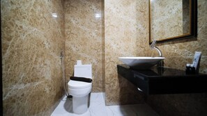 Bathroom features a toilet, sink with a vessel basin, and handheld showerhead.