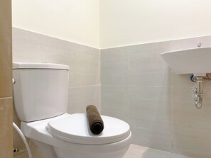 A bathroom with a toilet, a sink, and tiled walls.