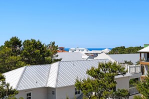 Un área residencial costera con casas de techos inclinados y vista despejada al océano.