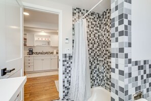 A bathroom with a shower, a bathtub, and a sink. - Commuter-Friendly Seattle Apartment! Dogs Welcome (Seattle)