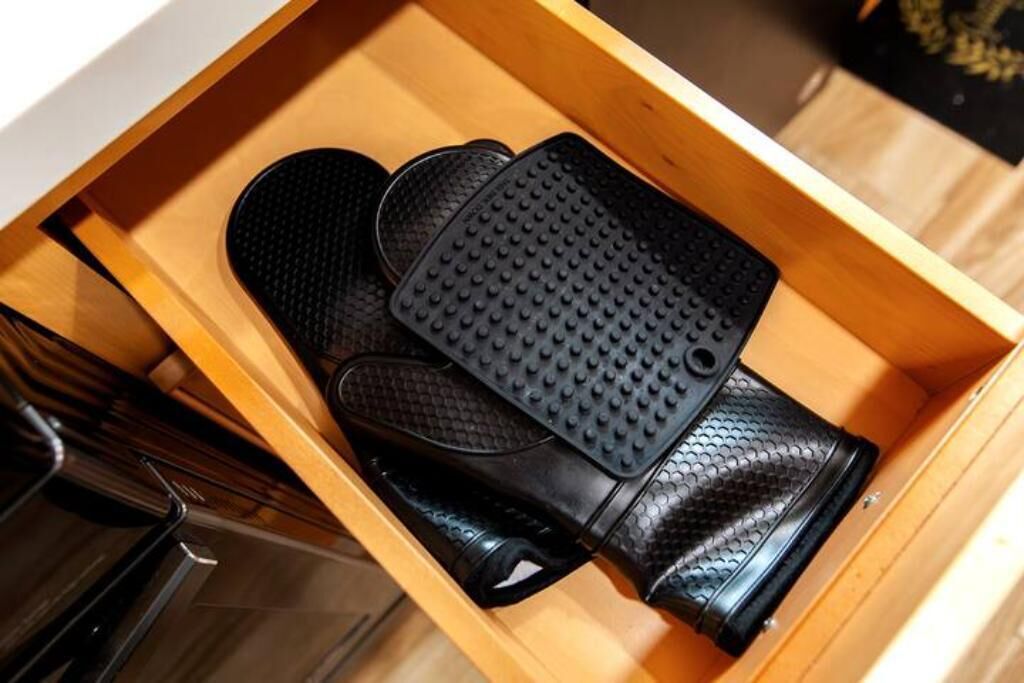 Un tiroir contenant des chaussures noires à semelles texturées.