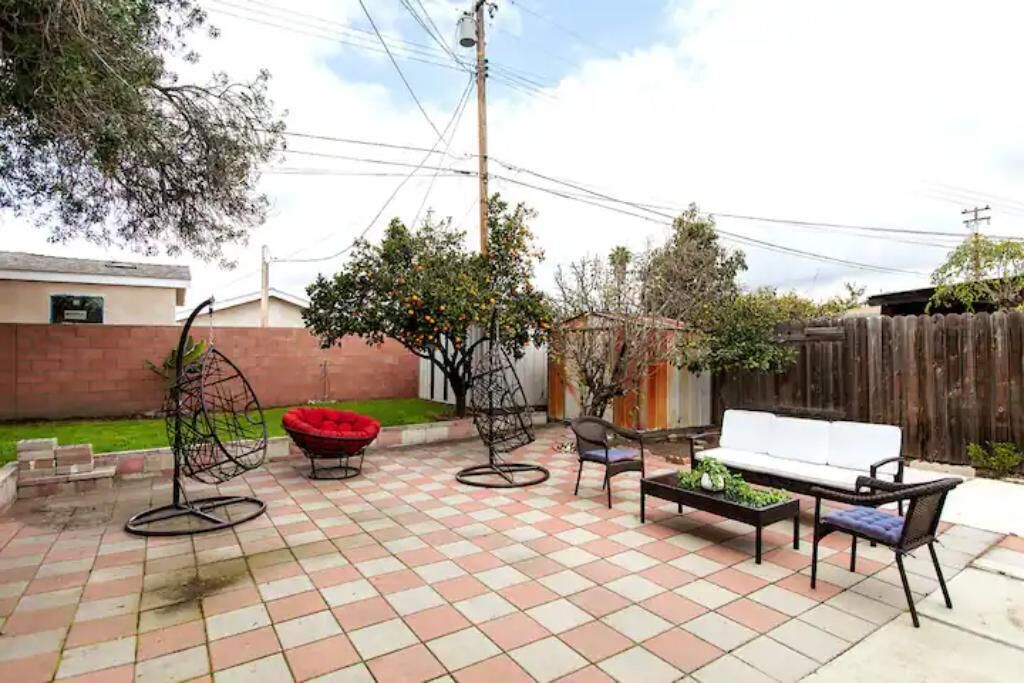 A patio with a checkered tile floor, a white sofa, and several chairs.