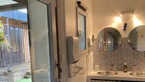 A modern kitchen with a large window, a built-in sink, and a decorative mirror. - Villa 290m2, Piano, Piscine et Spa, Parc Arboré Entre Bordeaux et St Emilion (Sallebœuf)