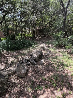 Eine natürliche Landschaft mit Bäumen, Felsen und einem Weg.