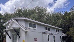 A single-story building with a front porch, a staircase, and a small deck.