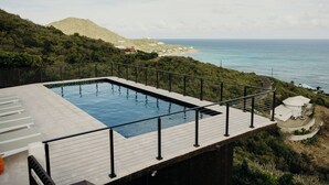 Una piscina en la azotea con vistas al mar y a la montaña.