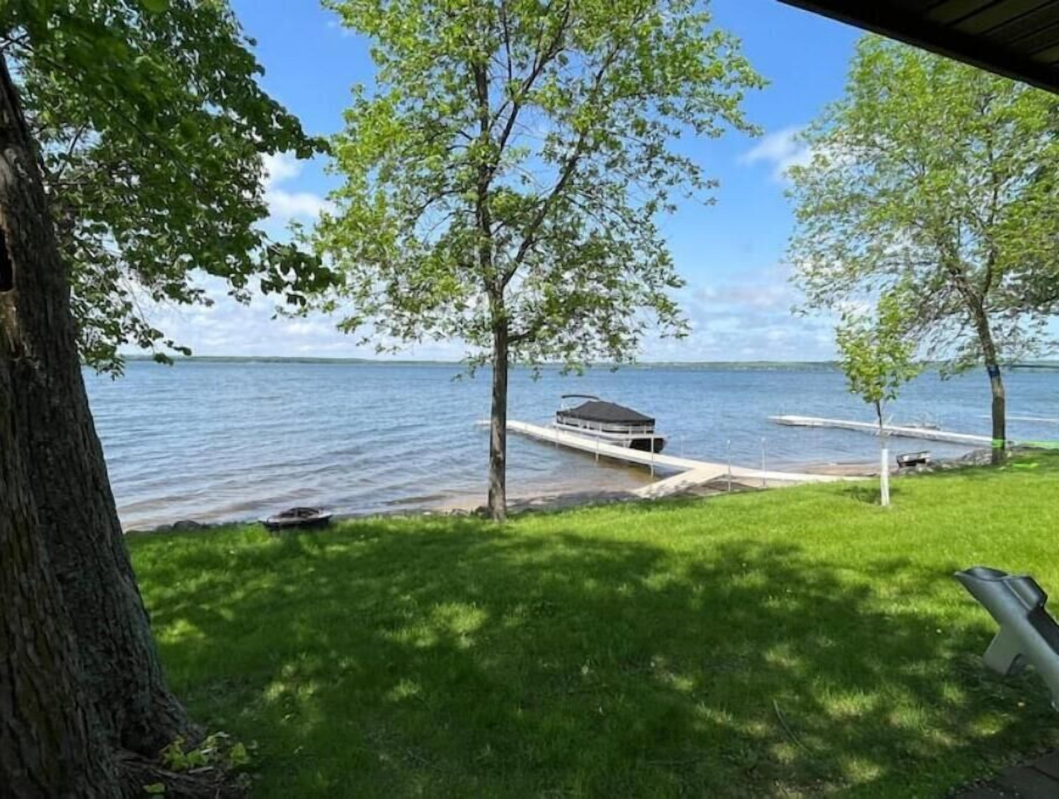 Une vue sur le lac, avec un quai, une rampe d’accès à l’eau abritée et une zone herbeuse.