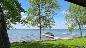Une vue sur le lac, avec un quai, une rampe d’accès à l’eau abritée et une zone herbeuse.