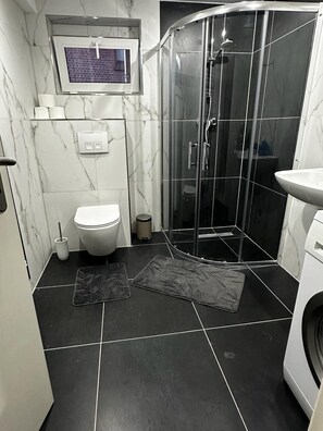 Een douche, handdoeken, zeep, toiletpapier