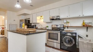 A modern kitchen with white cabinets, stainless steel appliances, and a central island. - Green Door Cutie Close to Everything in The Fort! (Fort Worth)