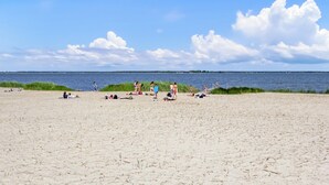 A beach with people sunbathing and walking along the shore. - Ferienwohnung Bodstedt (Bodstedt)