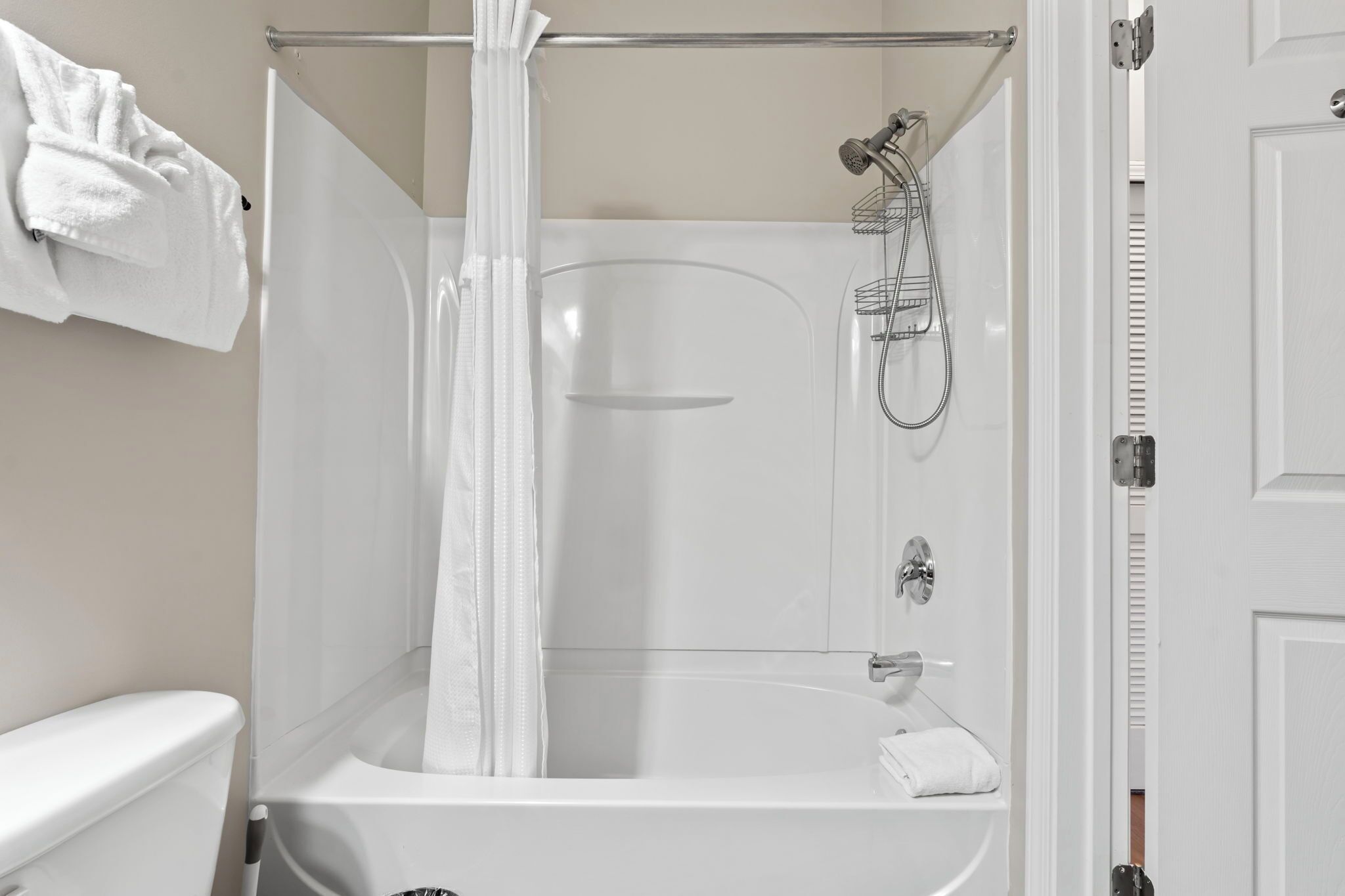 Un baño moderno con cabina de ducha de vidrio, una bañera blanca y un inodoro.