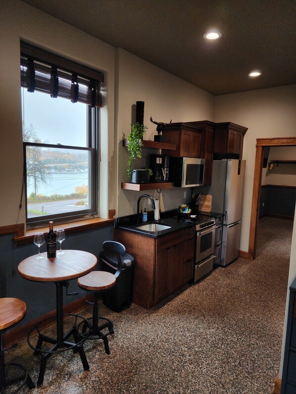 A compact kitchen with a dining area, a window with a view, and built-in appliances.