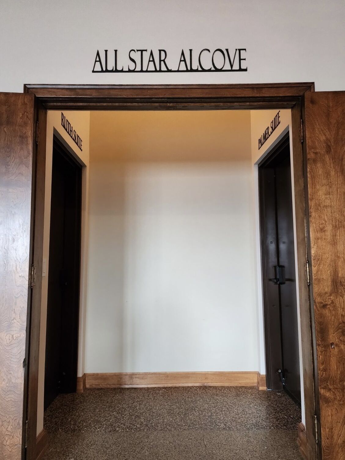 Ein leerer Raum mit einem Schild über der Tür, auf dem 'ALL STAR ALCOVE' steht, und zwei Türen mit den Aufschriften 'RUSH SQUARE' und 'BANNER SQUARE'.