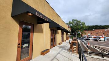 A building with a 'PALMER SUITE' sign, outdoor seating, and a U-Haul truck parked outside.