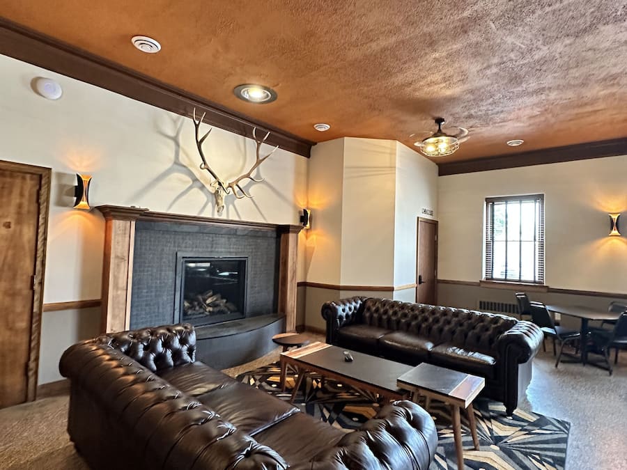 A spacious living room with a fireplace, leather sofas, and a dining area.