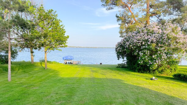 A grassy area with a covered picnic table and a view of a lake. - Cozy 3 bedroom, 1 bath home on Beaver Dam Lake (Beaver Dam)