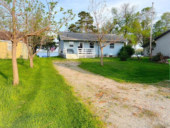 A house with a porch, a gravel path, and a grassy yard.