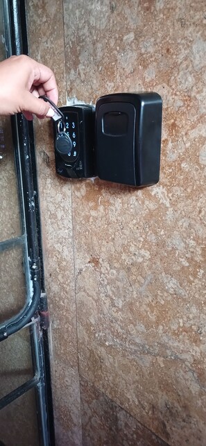A hand inserting a key into a black electronic lock on a door. - 201 Apartamento Completo Rers en Versalles 3 Habitaciones - Cali Tower Suites & Lofts (Cali)