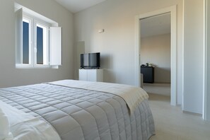 Une chambre à coucher avec un lit, une télévision et une armoire.
