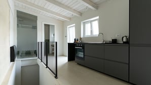 A modern kitchen with a built-in oven, a sink, and a window providing natural light.