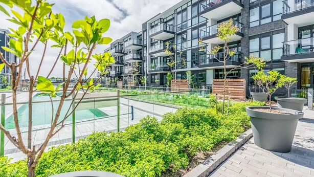 Un immeuble d’appartements moderne doté de nombreux balcons et d’un jardin sur le toit.