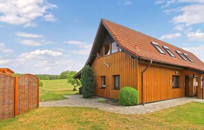 Une maison en bois avec un toit en pente et un petit porche.